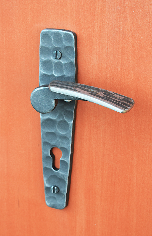 Tato kovaná klika má svoji úchopovou část vyrobenou z nerezové oceli