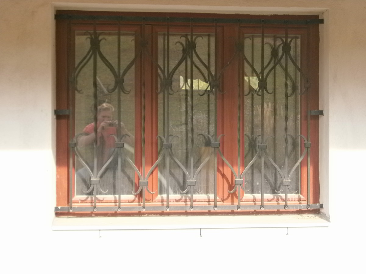Kované mříže na okna v jednoduchém ozdobném stylu. 