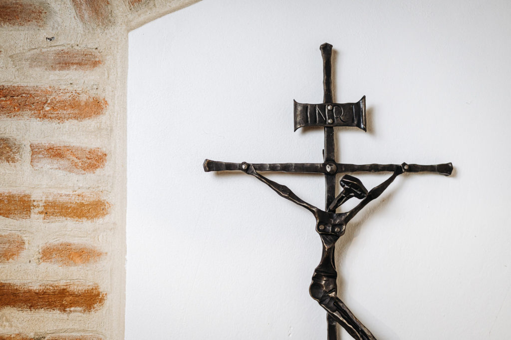 Detail kovaného kříže na zeď.