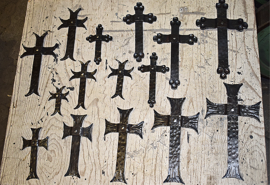 Různé ručně kované kříže na zeď. Historický styl. Interiér i exteriér